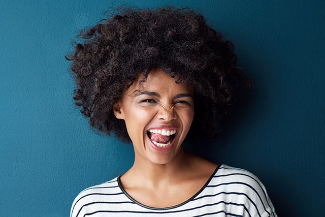 woman smiling after with the tip of her tongue on her front teeth