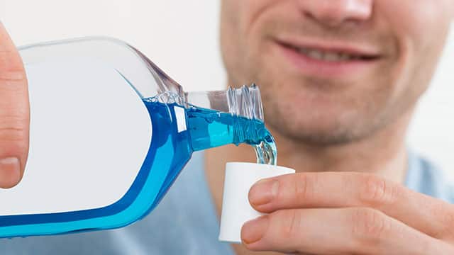 A close up of a man using mouthwash A close up of a man using mouthwash