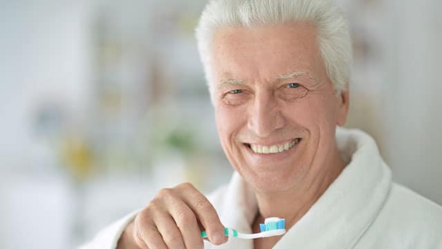  older man brushing his teeth