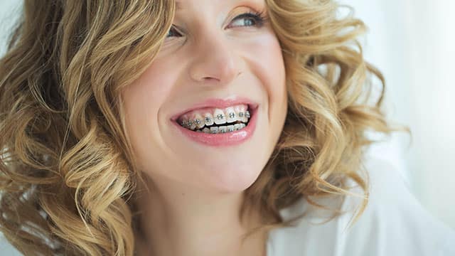 Woman smiling while wearing braces