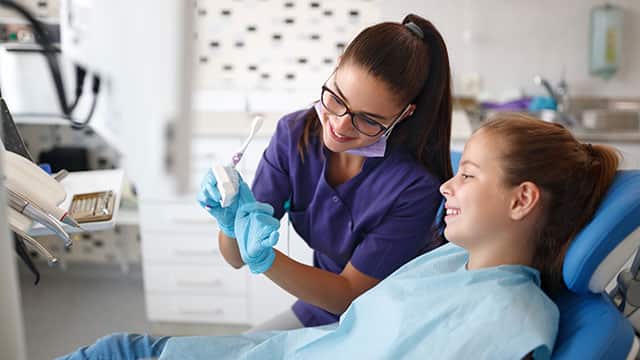 Female dentist with little girl patient