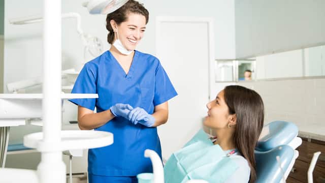 Dentist talking to patient in chair