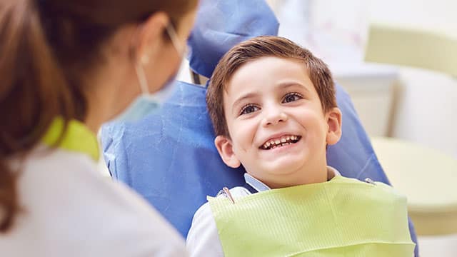 A smiling child with a dentist in a dental office