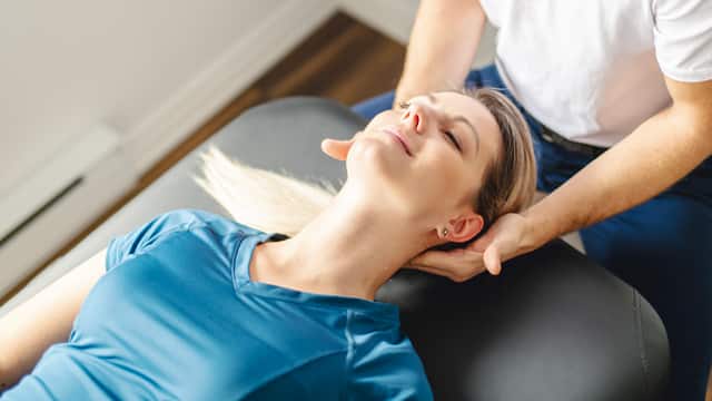 Young woman in a blue shirt getting a chiropractic adjustment