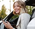A beautiful businesslike woman sitting in car and using cellphone