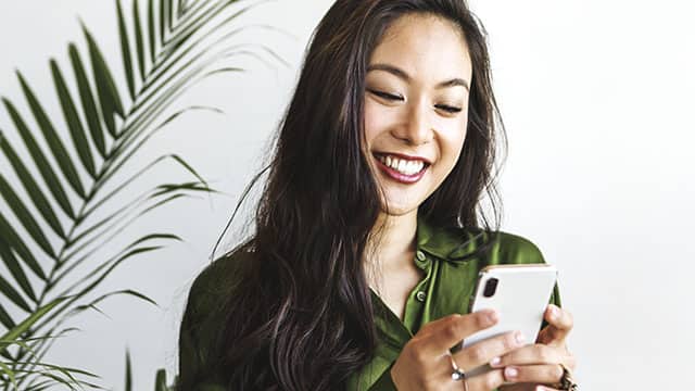 Woman smiling and texting on smartphone