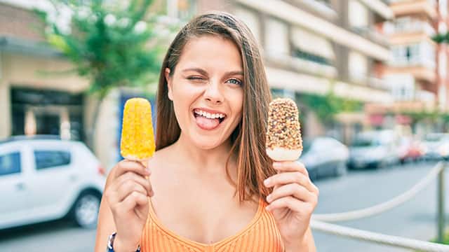  young woman biting her tongue and winking holding an ice cream