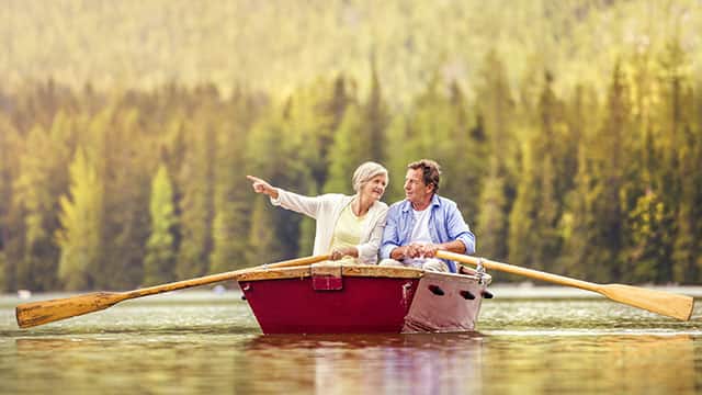 An older couple in a rowing boat on a lake