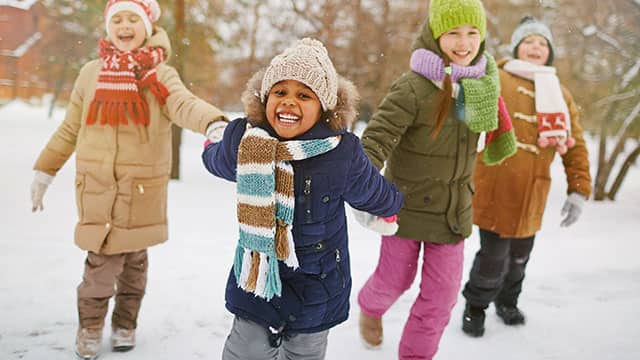 A group of four children playing outdoors in the winter time