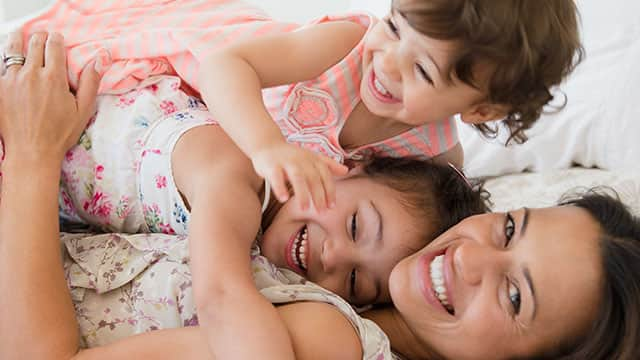 Mother and two daughters in bed