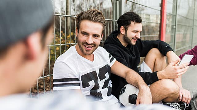 young soccer players sitting outside the field