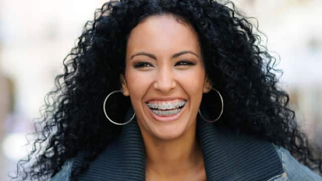 A young black woman smiling with braces