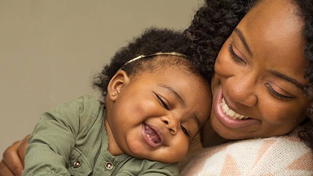 mother and daughter smiling while hugging