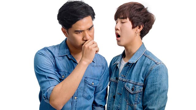 Asian man thinking and the other yawning Two young men testing their breath