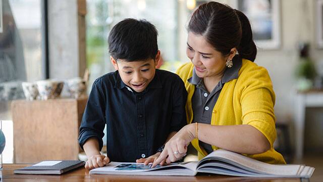 Mother teaching her son oral care activities