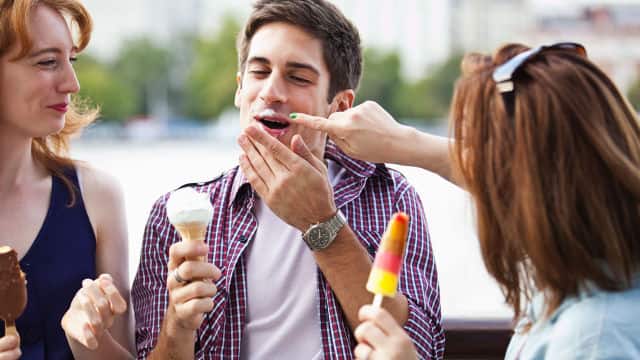 two women and a man smiling eating ice cream