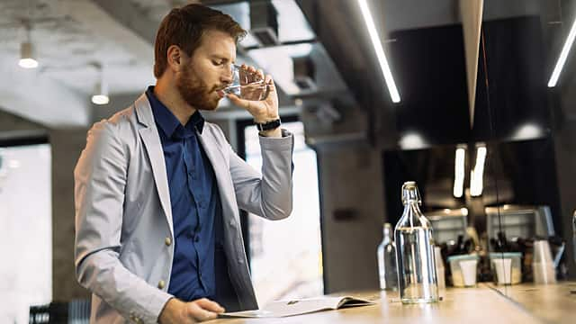 a man is drinking water to ease dry throat