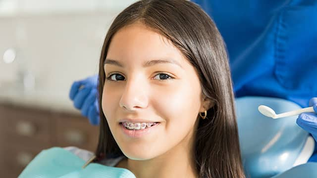 Joven sonriendo con brackets autoligables