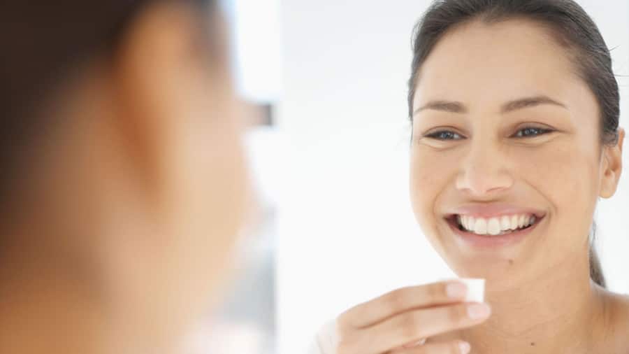 Close-up of young woman rinsing her mouth with mouthwash