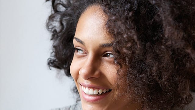 Close up portrait of woman smiling and looking away