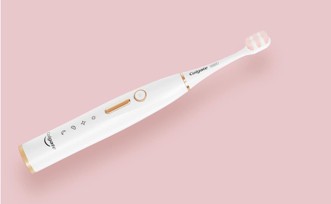 Colgate Electric Toothbrush against pink background