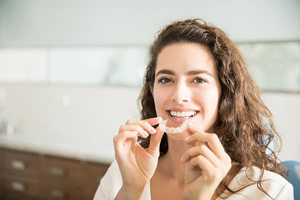 Mujer sonriendo con placa