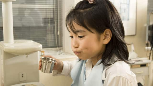 Niña utilizando un enjuague bucal