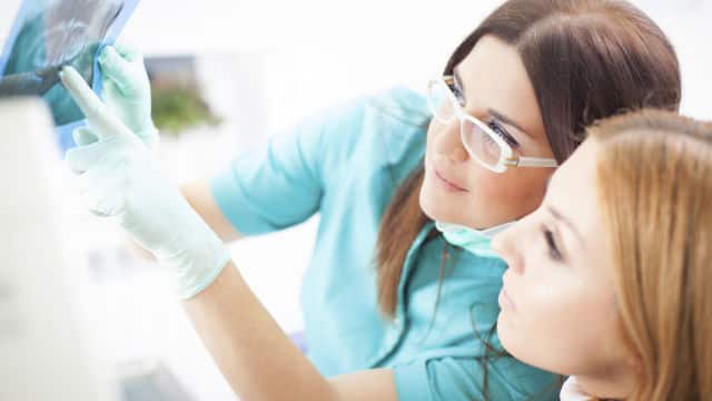 Dentista mostrando radiografía dental a su paciente
