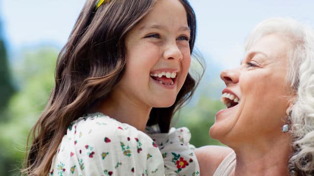 a mother smiling while holding her daughter