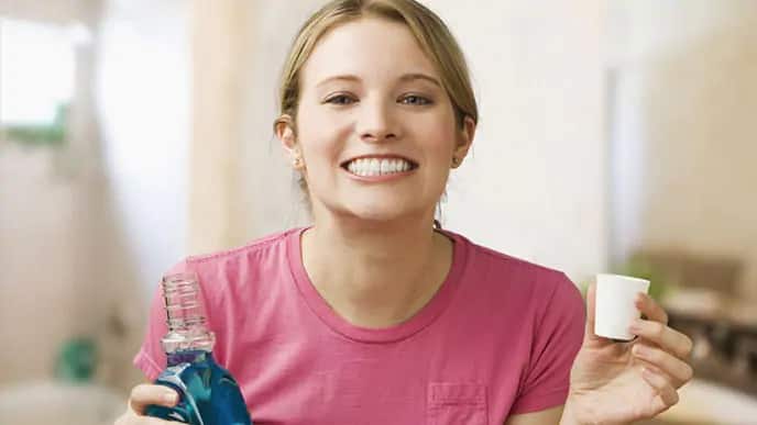 Girl smiling after using fluoride mouth rinse 