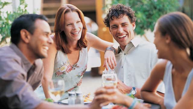 two couple laughing while enjoying drinks