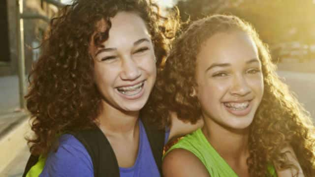 Two female friends laughing outdoors