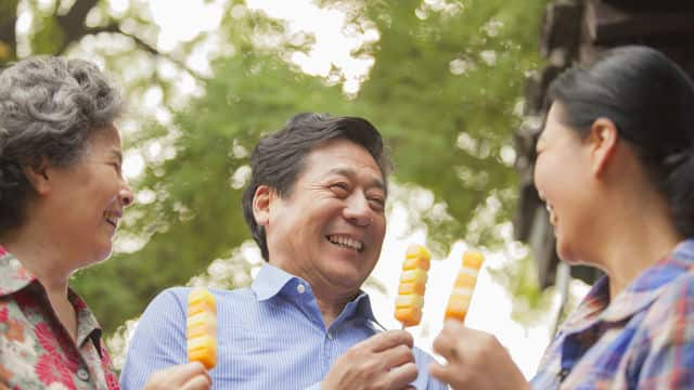 Familia sonrie con comida en la mano 