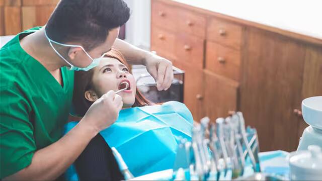 Dentist treating female patient for enamel erosion