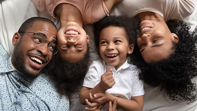 happy family is laughing in bed