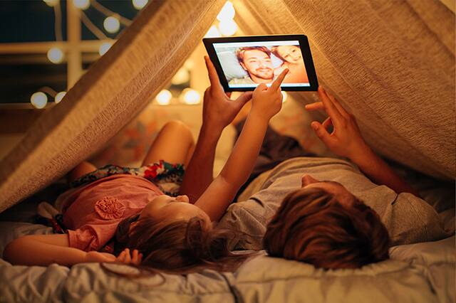 Father and daughter taking a selfie under a tent