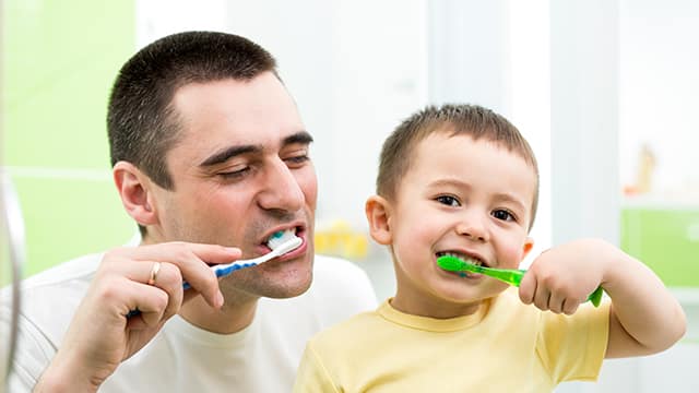 padre e hijo lavándose los dientes
