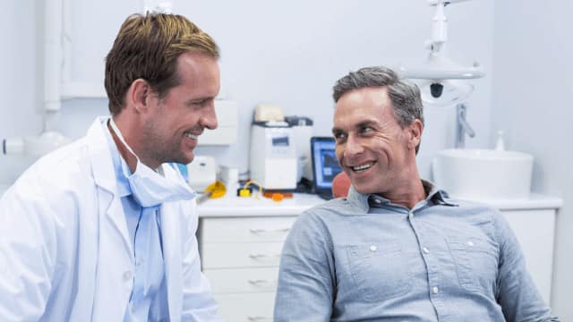 dentist interacting with male patient in the dental office