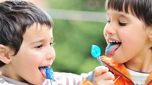 Niños lamiendo dulce