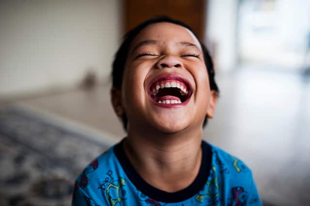 Young boy laughing in home