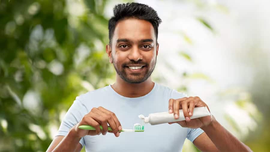 A confident young man happily using the best toothpaste for bad breath