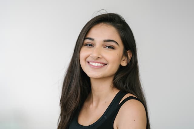Girl showing her teeth after using teeth whitening kit