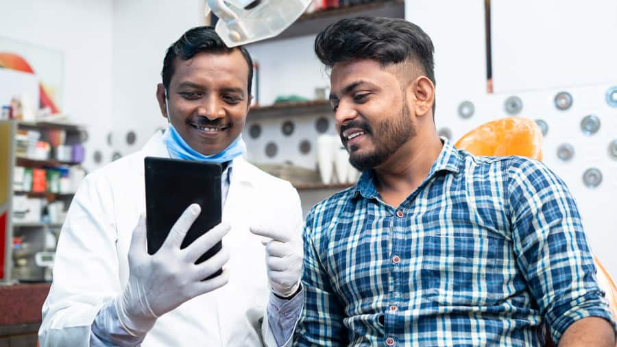 doctor and patient checking x-ray while sitting at a desk in a dental office