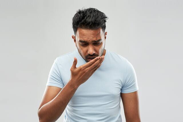 A concerned young man thinking about bad breath treatment