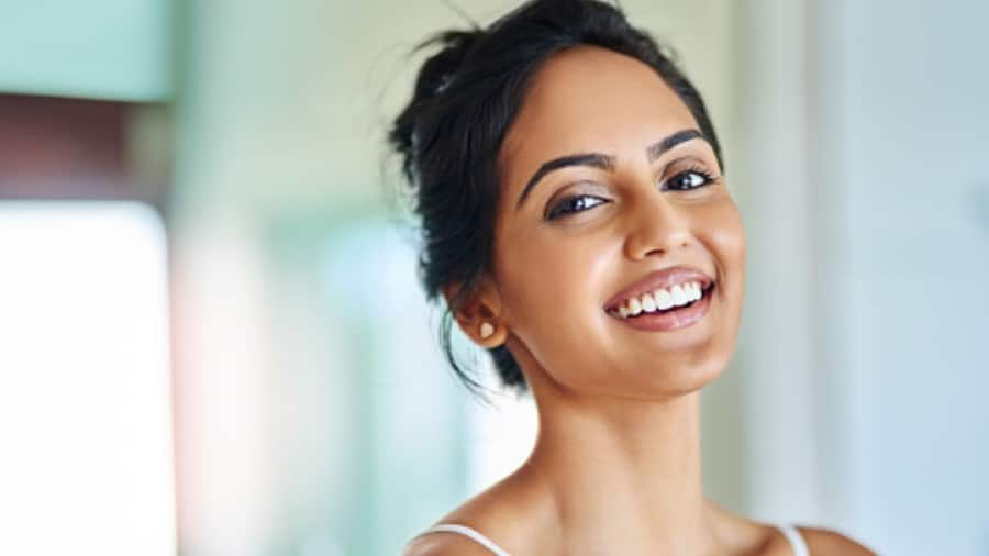 young lady smiling, showcasing bright teeth unaffected by yellow stains 