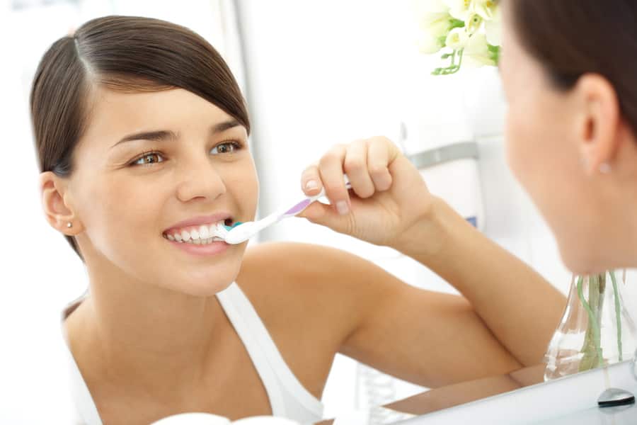 Mujer jóven lavándose los dientes
