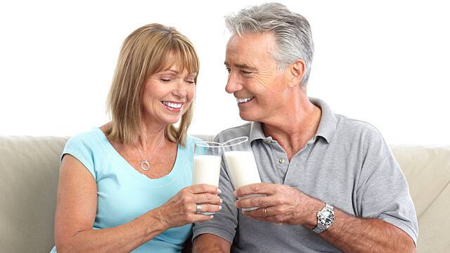 Pareja tomando leche y sonriendo