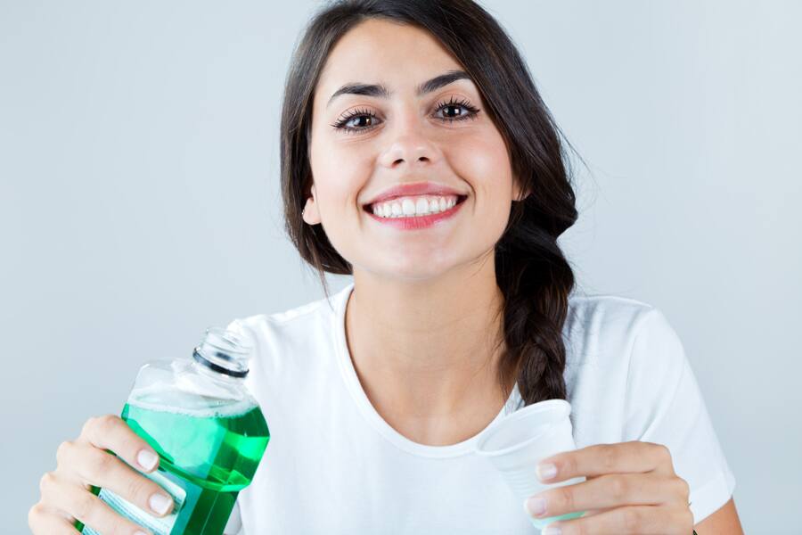 Mujer de sonrisa brillante usando enjuague bucal