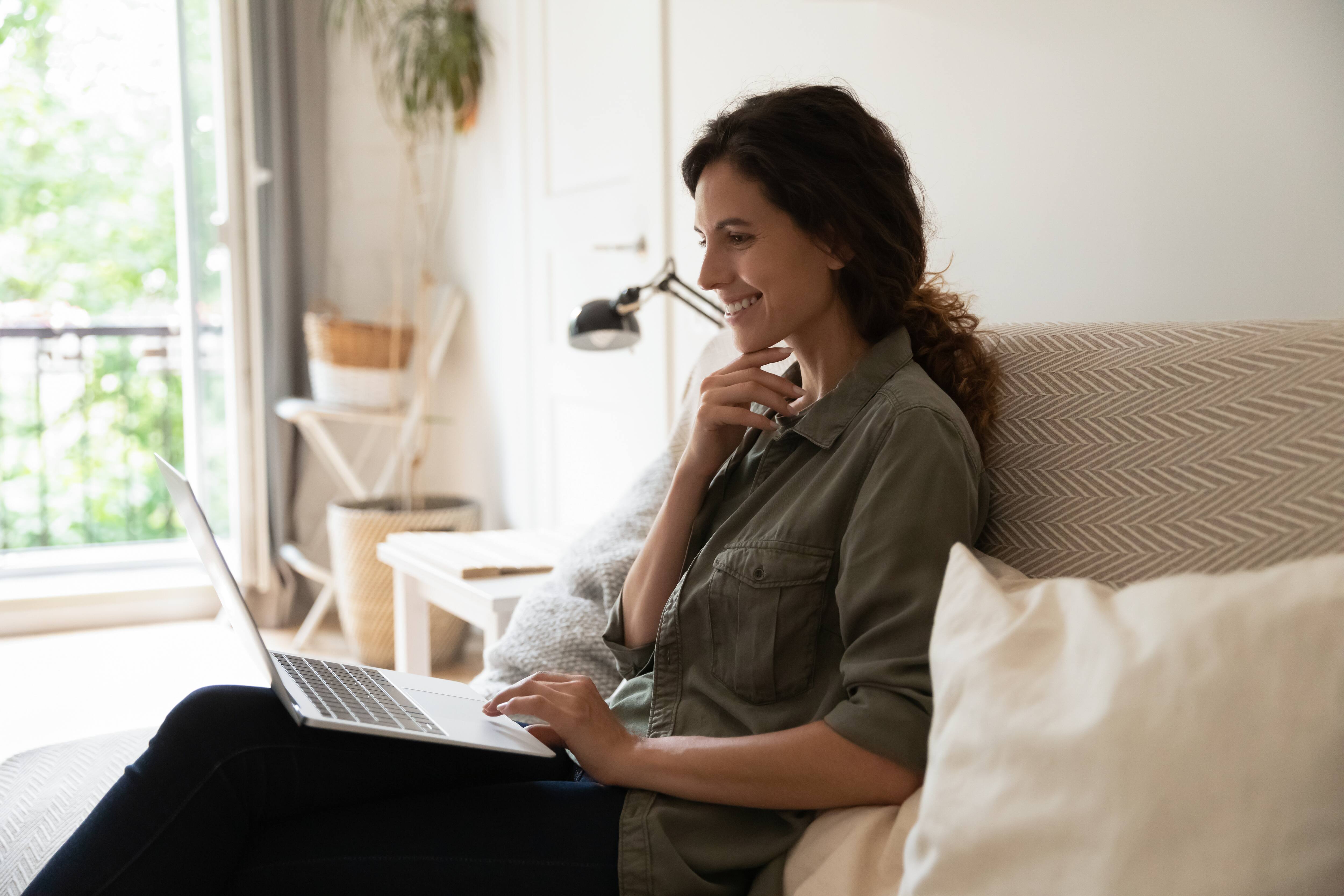 Mujer sonriendo mientras está en su computador