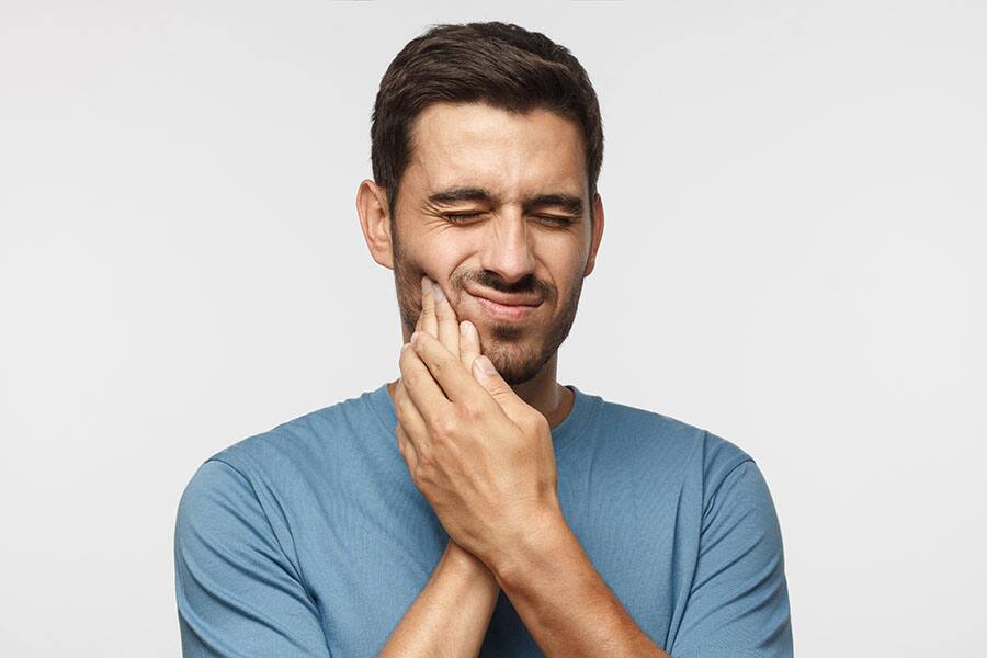 young man holding tooth ache